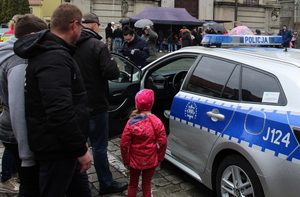 policjantka przekazuje uczestnikom festynu materiały promocyjne