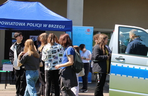 młodzież i policjanci przy stoisku policyjnym podczas dni otwartych na placu przed szkołą