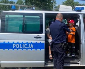 policjant pokazuje radiowóz dzieciom