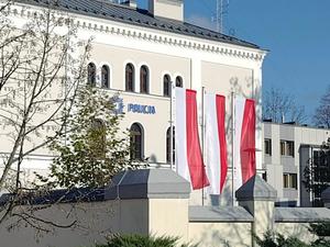 budynek komendy policji, przed nim trzy flagi polski
