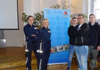 policjantki i maturzyści na tle baneru KPP w Brzegu