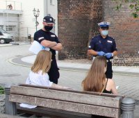 Policjanci rozdają ulotki z informacjami o służbie w Policji