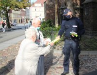 policjanci rozdają ulotki seniorom