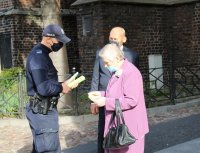 policjanci rozdają ulotki seniorom