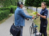 policjantka przekazuje kamizelkę odblaskową rowerzyście