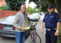 policjant przekazał kamizelkę odblaskową rowerzyście