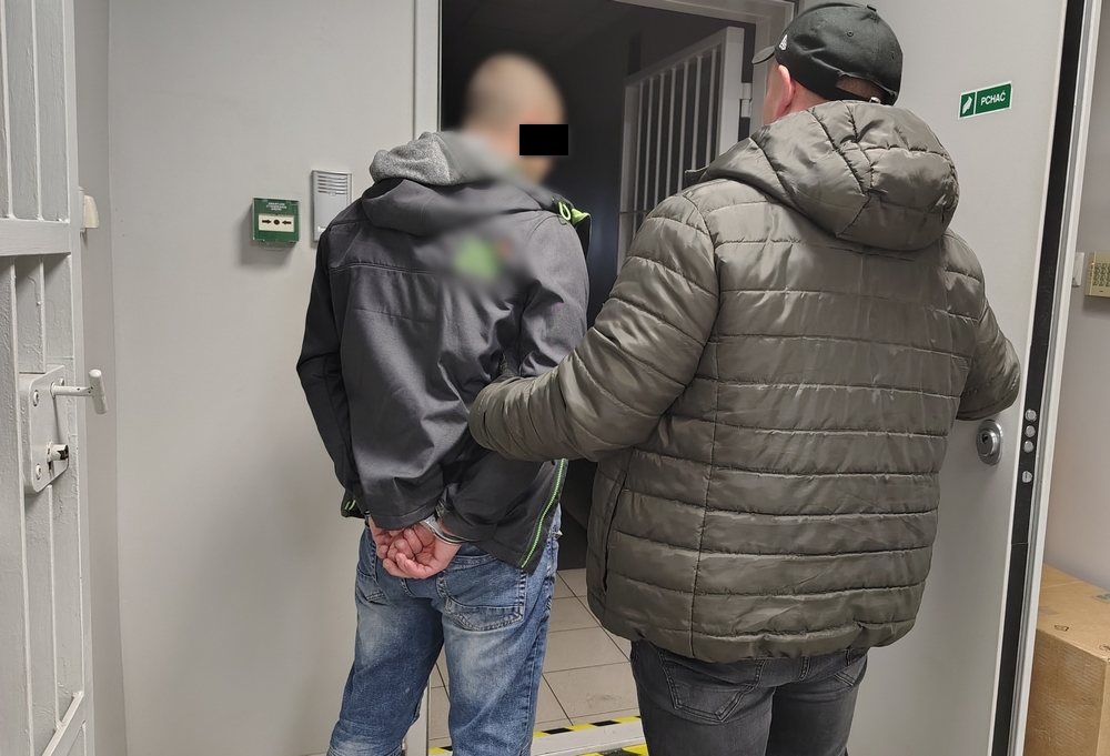 policjant prowadzi zatrzymanego