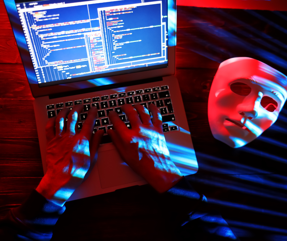 dłonie na klawiaturze laptopa, obok biała maska