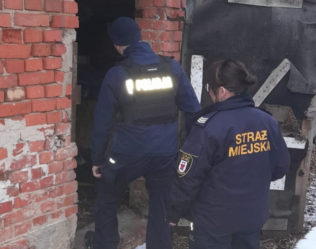 policjant i strażnik miejski wchodzą do pustostanu