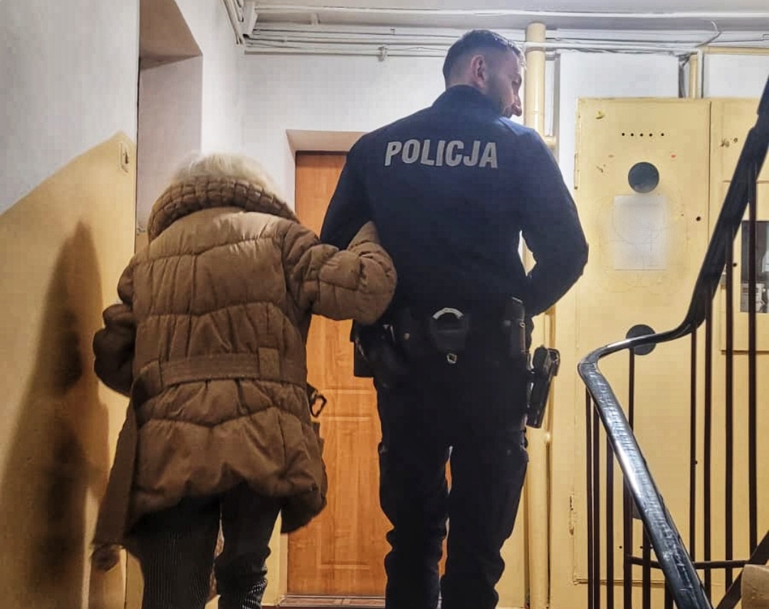 dzielnicowy prowadzi seniorkę