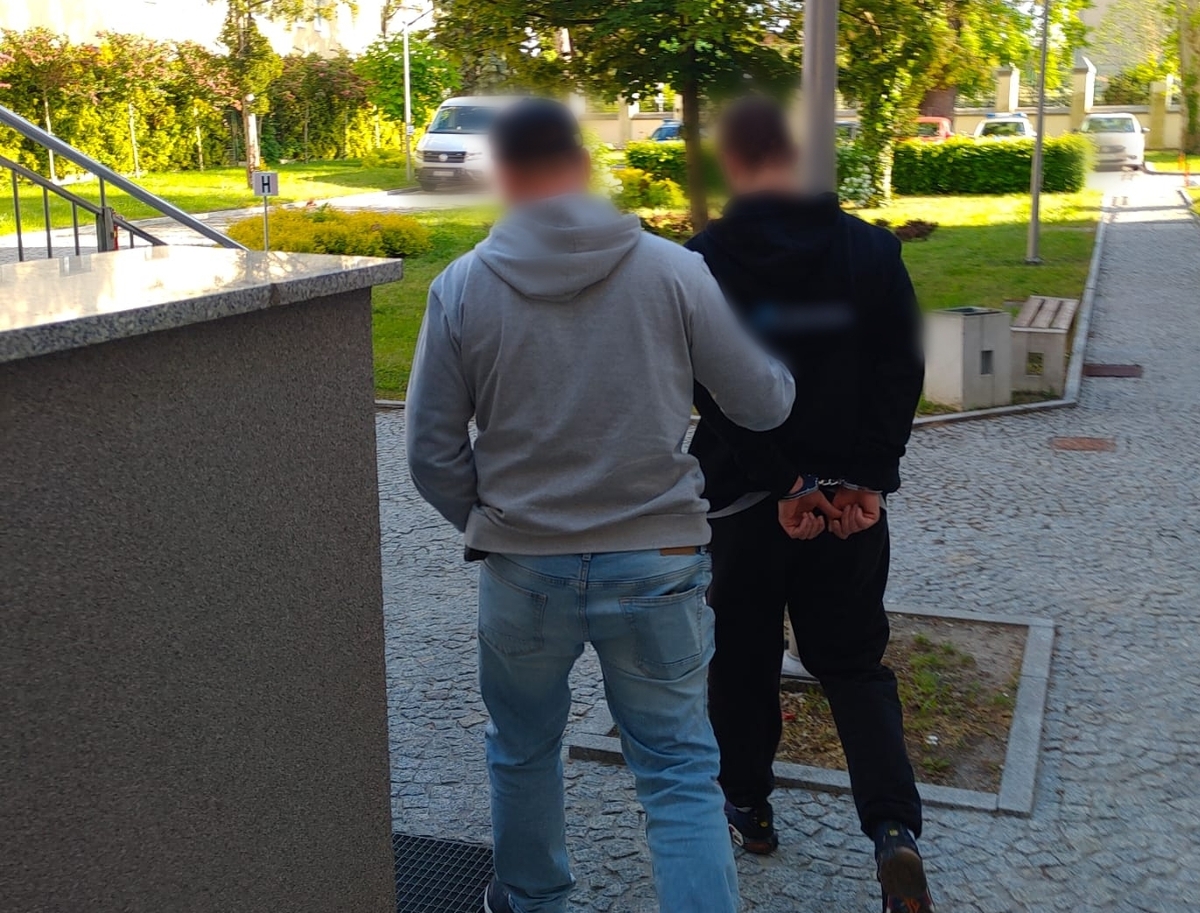 nieumundurowany policjant prowadzi zatrzymanego
