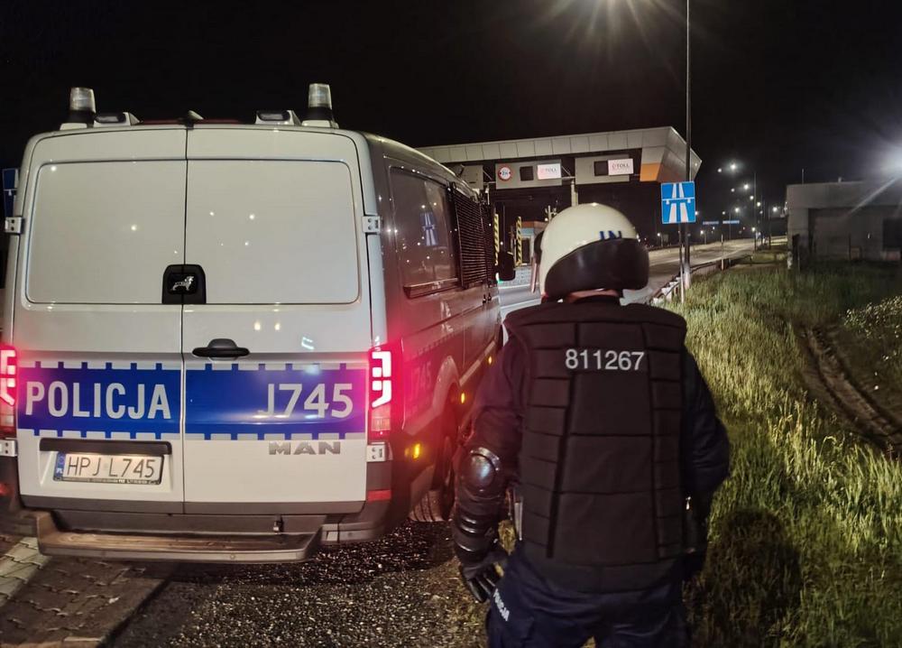 radiowóz w nocy stoi przy wjeździe na autostradę