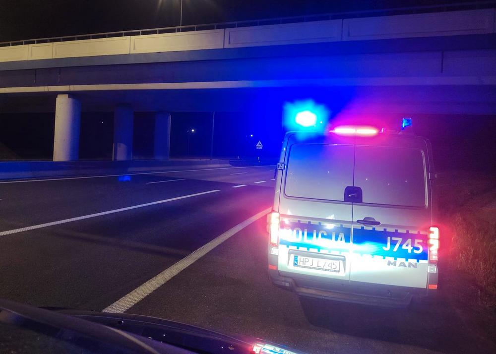 radiowóz na sygnałach świetlnych w nocy