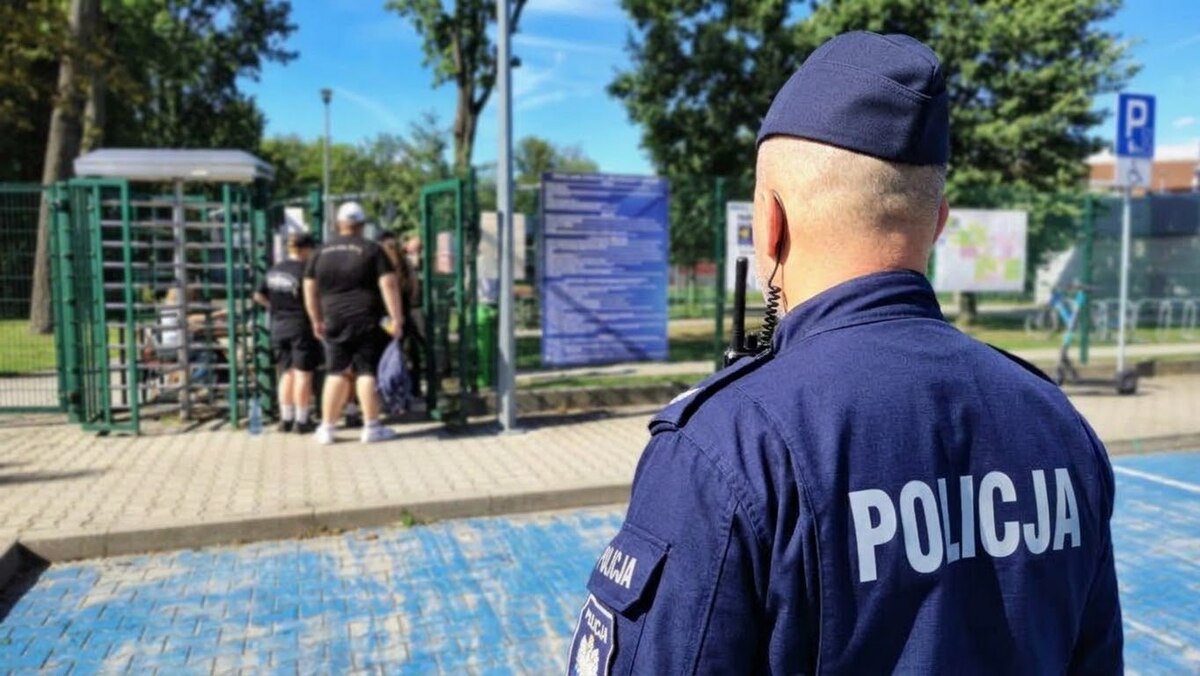 policjant obserwuje bramkę wejściową na stadion