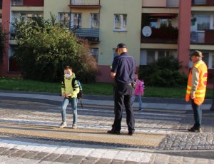 w rejonie przejścia dla pieszych policjant obserwuje ruch pieszych w pojazdów