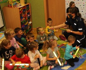 policjantka rozdaje dzieciom odblaski