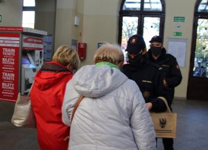 funkcjonariusze straży ochrony kolei rozdają maseczki ochronne