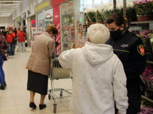 strażniczka miejska przekazuje starszej kobiecie maseczkę ochronną