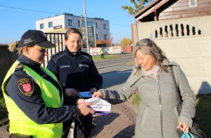 mundurowi przekazują materiały promocyjne i maseczki ochronne