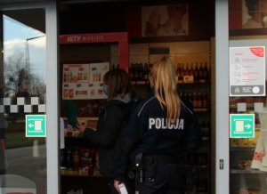 policjantka wchodzi na stację paliw