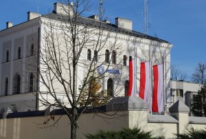 Budynek Komendy Powiatowej Policji w Brzegu przed nim trzy flagi Rzeczpospolitej