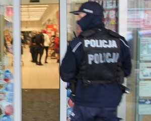 umundurowany policjant wchodzi do marketu