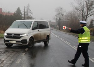 umundurowany policjant zatrzymuje do kontroli samochód