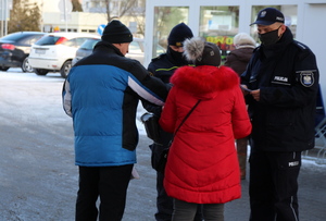 policjanci i strażnicy miejscy rozdają maseczki i rozmawiają z seniorami