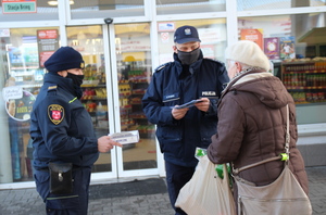 policjanci i strażnicy miejscy rozdają maseczki i rozmawiają z seniorami