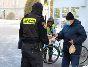 policjanci i strażnicy miejscy rozdają maseczki i rozmawiają z seniorami