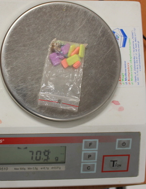 kolorowe tabletki w woreczku foliowym na wadze
