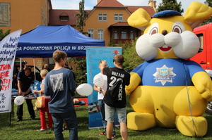 Umundurowani policjanci podczas Opolskich Dni rodziny przekazują dzieciom materiały promocyjne