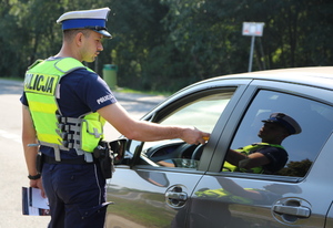 umundurowany policjant bada stan trzeźwości kierowcy