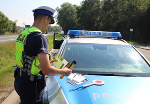policjant bierze materiały edukacyjne