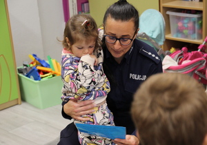 policjantka ogląda z dziewczynką laurkę
