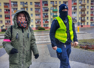 policjant i uśmiechnięta kobieta w rejonie przejścia dla pieszych