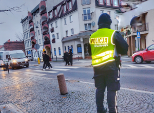 umundurowany policjant patroluje miasto w rejonie przejścia dla pieszych