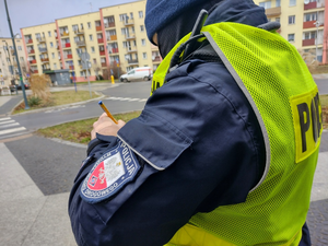 umundurowany policjant pisze w notatniku