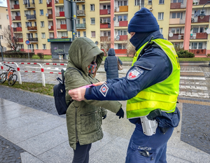 policjant przekazuje opaskę odblaskową kobiecie