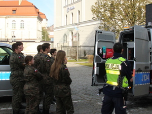 umundurowani policjanci prezentują radiowóz młodzieży z klas mundurowych