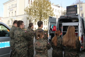 umundurowani policjanci prezentują radiowóz młodzieży z klas mundurowych