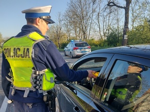 policjant przy wykorzystaniu alco-blow bada kierowce na trzeźwość