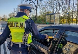 policjant przy wykorzystaniu alco-blow bada kierowce na trzeźwość