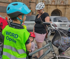 dzieci w sportowych strojach, w kaskach ochronnych na glowie