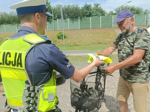 policjant przekazuje kamizelkę