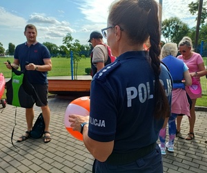 policjantka trzyma pomarańczową piłkę