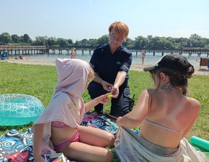 policjantka na plaży rozmawia z dziećmi