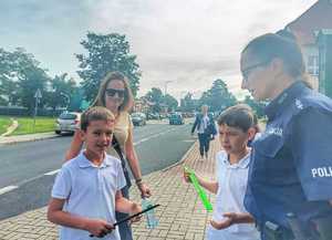 policjantka przekazuje odblaski chłopaką