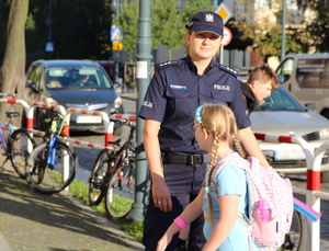 umundurowana policjantka przekazuje odblask dziewczynce