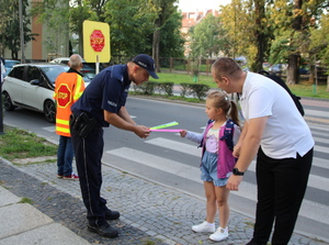 policjant rozdaje dzieciom odblaski